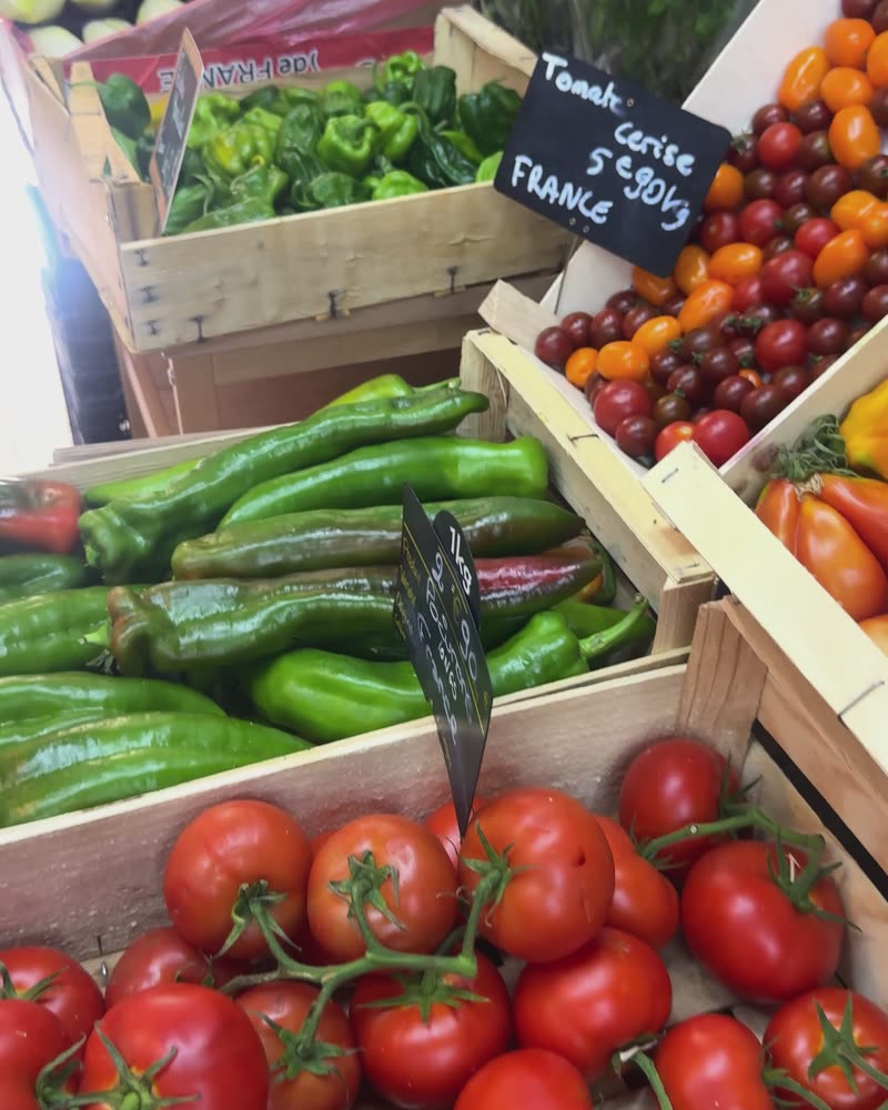 Cageots de tomates cerises, de piments verts et de tomates grappe.